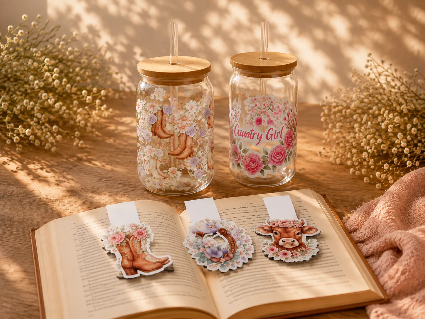 Floral cowgirl-themed glass tumblers and country-inspired magnetic bookmarks in warm sunlight